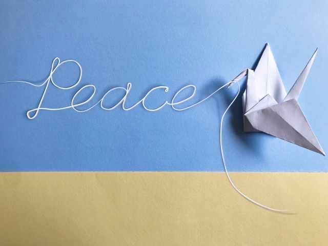 世界の平和を祈る白い折り鶴とpeaceの文字